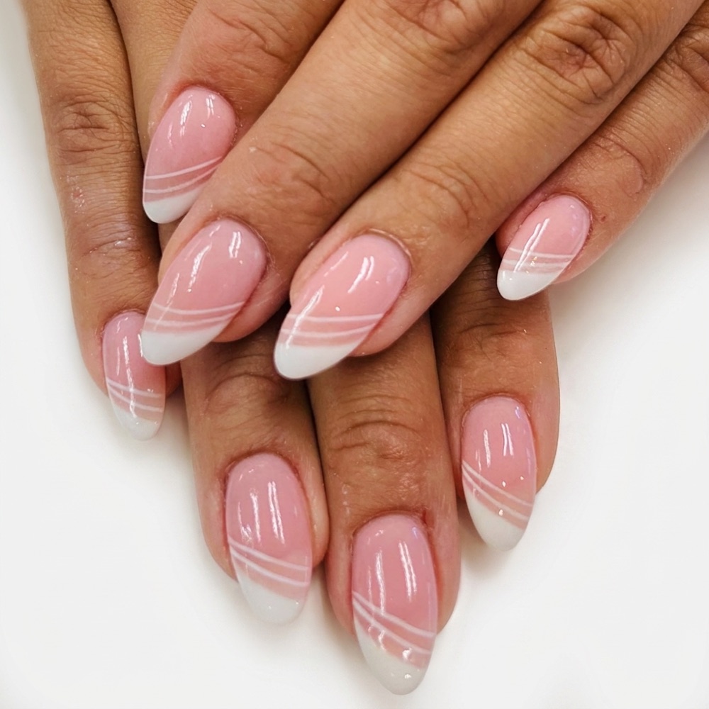 Almond nails in sheer pink with diagonal white French tips and fine pinstripes